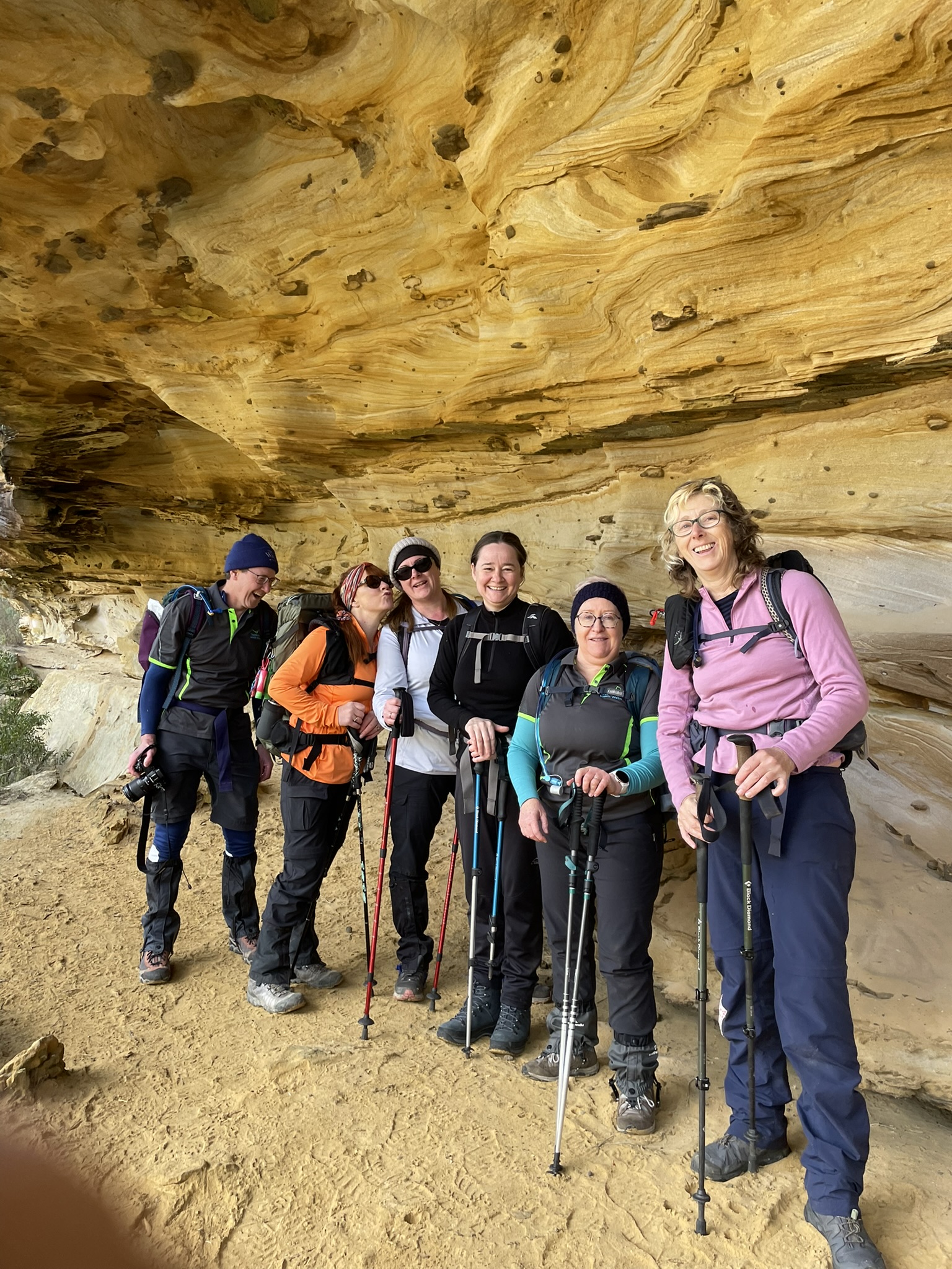 a group of hikers standing in front of a standstone feature that Bluff River Gorge hike is famous for